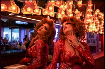 Stunning drag queen stands seductively in front of a mirror at 801 Bourbon Bar in Key West